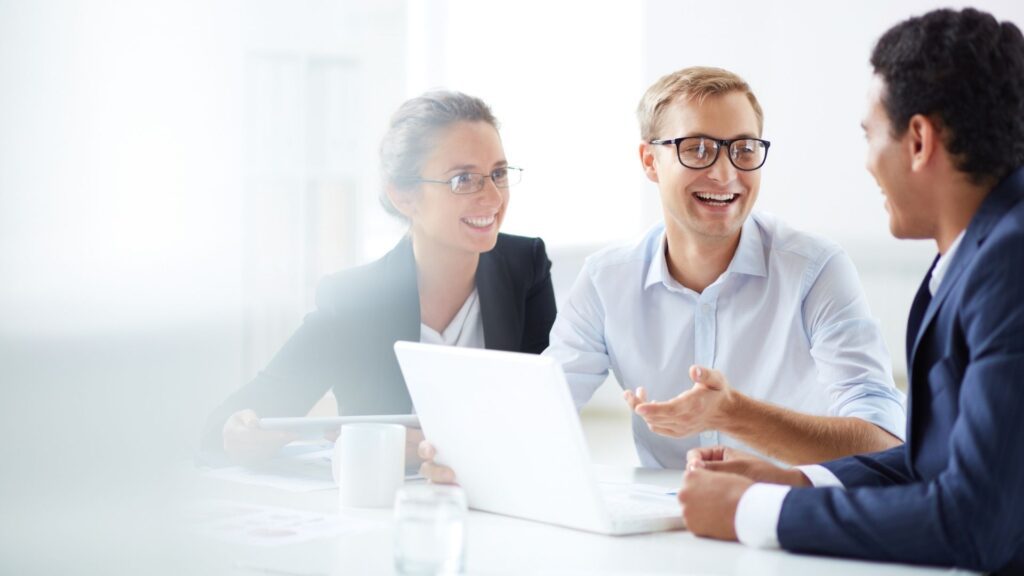 three people smiling in meeting